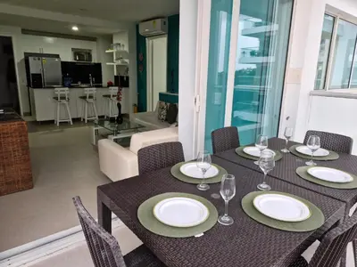 a dining room table with plates and wine glasses at Apartamento con vista al Mar Cartagena Morros 3 in Cartagena de Indias