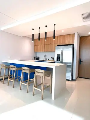 a kitchen with a blue island and bar stools at Apartment Hilton Garden Inn Building in Barranquilla