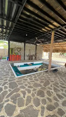a pavilion with blue and white tables on a stone floor at Mojarra Beach Casa privada Vista al mar in Salina de Rey