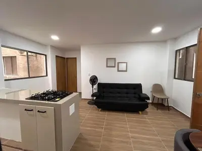 a living room with a black couch and a stove at Apartamento Villa Mary C-202 in Coveñas