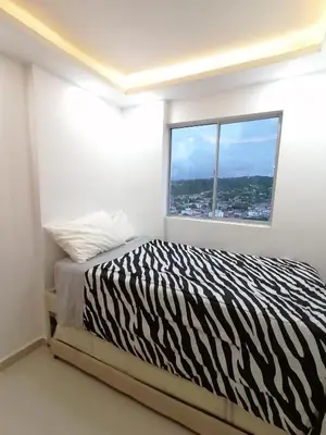 a zebra print bed in a white room with a window at Apartamento Rosedale in Cartagena de Indias