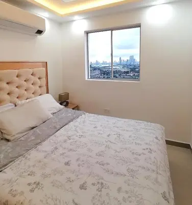 a bedroom with a large bed and a window at Apartamento Rosedale in Cartagena de Indias