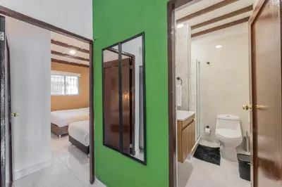 a bathroom with a toilet and a green wall at Amplio apartamento familiar de 2 habitaciones dentro de la Ciudad Amurallada - AC, Wifi rapido y Agua caliente in Cartagena de Indias