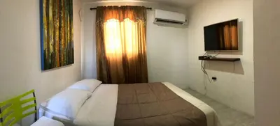 a bedroom with a bed and a window with a television at El taller del artista I in Cartagena de Indias
