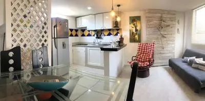 a kitchen and living room with a glass table at El taller del artista I in Cartagena de Indias