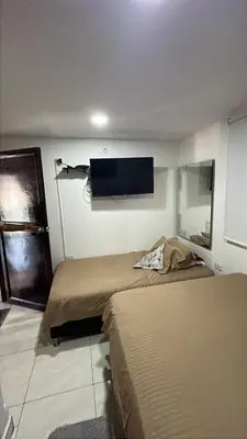 a room with two beds and a tv on the wall at Casa Étoile ideal location Ctg in Cartagena de Indias
