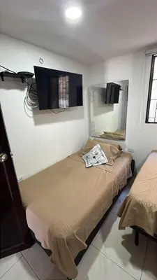 a bedroom with two beds and a flat screen tv at Casa Étoile ideal location Ctg in Cartagena de Indias