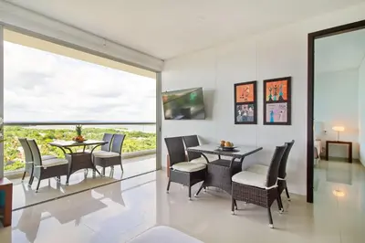 a dining room with a table and chairs and a large window at Beach 2-bedroom apartment in Cartagena de Indias