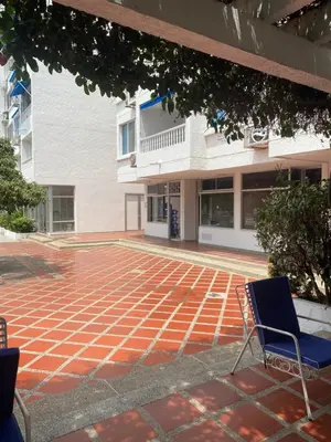 a pair of chairs sitting on a brick patio in front of a building at Playa Los alcatraces in Santa Marta