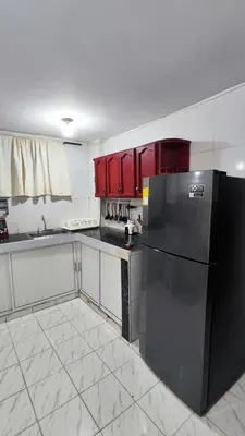 a kitchen with a black refrigerator and red cabinets at Apartamento #3 in Puerto Colombia
