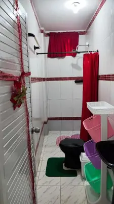 a bathroom with a shower with two toilets and a red curtain at Apartamento #3 in Puerto Colombia