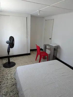 a bedroom with a bed and a desk and a red chair at BAQ central point in Barranquilla