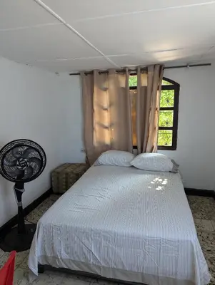 a bedroom with a bed and a window at BAQ central point in Barranquilla