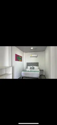 a bedroom with a bed and a painting on the wall at casa kite school in Cartagena de Indias