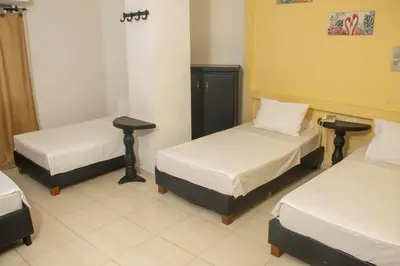 a room with two beds and two tables at Hotel Central in Sincelejo