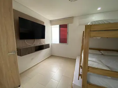 a bedroom with a bunk bed and a flat screen tv at Espectacular apto frente al mar in Coveñas