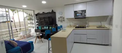 a kitchen with white cabinets and blue chairs in a room at Turquesa a 5 Minutos del aereopuerto Daniel Lemaitre in Cartagena de Indias
