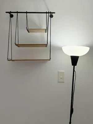 a glass lamp and a black pole next to a wall at Comfy apartment in historic center in Cartagena de Indias