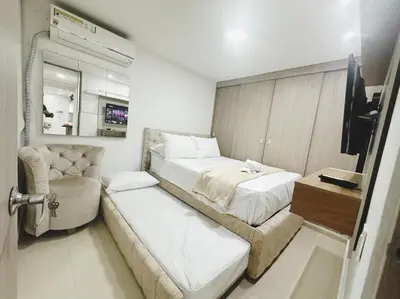 a small bedroom with a bed and a chair at Low cost 2A,TV 60 15 min B vista in Barranquilla