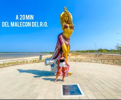 a woman standing in front of a statue of a monkey at Low cost 2A,TV 60 15 min B vista in Barranquilla