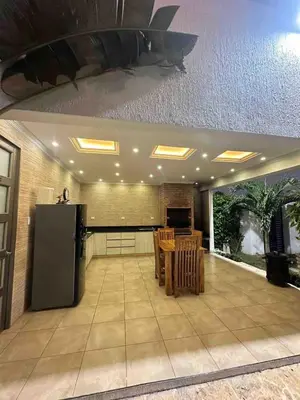 a large kitchen with a table and a refrigerator at Villa Maty Casa Campestre in Turbaco