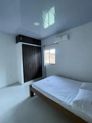 a white bedroom with a bed and a window at Apartamento Salome Coveñas in Coveñas