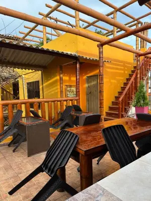 a patio with a wooden table and chairs on a deck at Hostal Bambumar in Cartagena de Indias