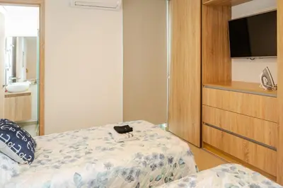 a bedroom with a bed and a dresser with a television at Paraíso Costero Apartamento de Lujo con Vista Directa al Mar in Cartagena de Indias