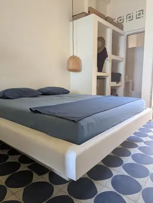 a bedroom with a large bed with a blue blanket at Casa en el Mar in San Onofre