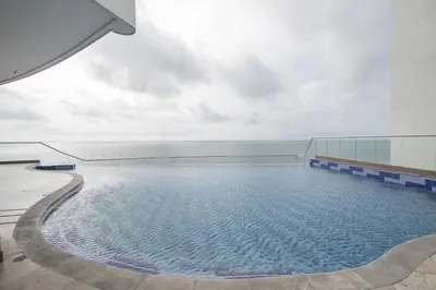 a swimming pool with the ocean in the background at Apartamento Palmetto Eliptic ICDI in Cartagena de Indias