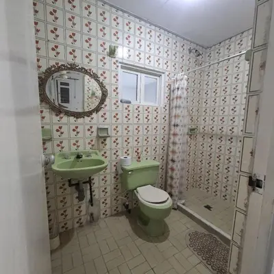 a bathroom with a green toilet and a sink at Habitación Girasoles in Cartagena de Indias