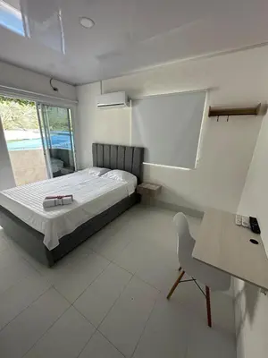 a bedroom with a bed and a table and a chair at Casa Campestre Valle del Mar in Santa Marta
