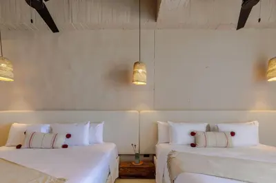 two beds in a room with white walls at HBE-P4 Penthouse Lujoso de 4 Habitaciones Frente al Mar con Wifi in Cartagena de Indias