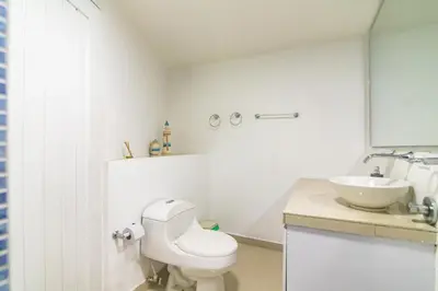 a white bathroom with a toilet and a sink at Casa de playa vistamare in Santa Marta