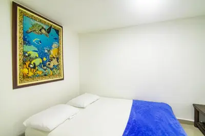 a bedroom with a bed and a painting on the wall at Casa de playa vistamare in Santa Marta