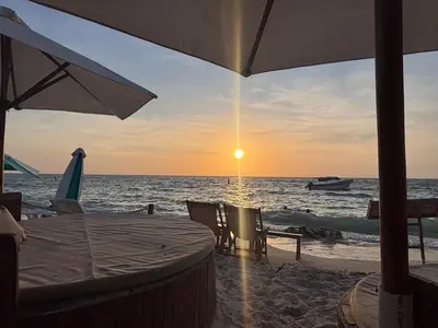 a table and chairs on the beach with the sunset at Euphoria Beach in Playa Blanca