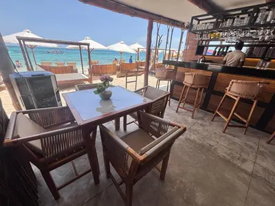 a restaurant with a table and chairs and the ocean at Euphoria Beach in Playa Blanca