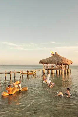 a group of people in the water near a pier at Hotel isla bonita in Tintipan Island