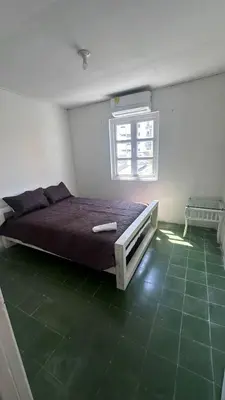 a bedroom with a bed in a room with a green floor at Apartamento de la A samblea in Cartagena de Indias
