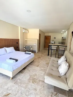 a bedroom with a bed and a couch and a kitchen at Apartment in Coveñas FOREST in Coveñas