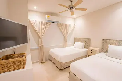 a bedroom with two beds and a flat screen tv at Modern and cozy Beachfront house Santa Marta 7pax in Simón Bolívar International Airport