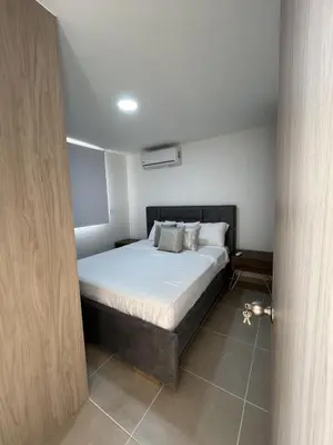 a bedroom with a bed with white sheets and pillows at Apartment with large balcony in Cartagena de Indias
