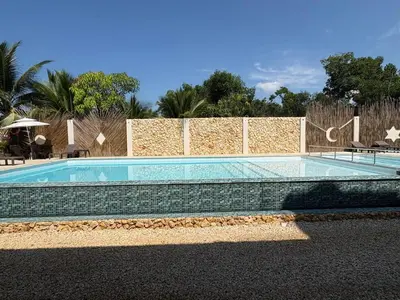 a swimming pool in front of a brick wall at Forest Condominio in Coveñas