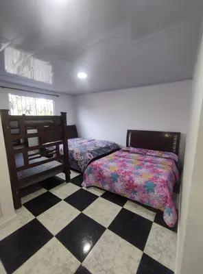 a bedroom with two beds and a checkered floor at Apartamento #6 in Puerto Colombia