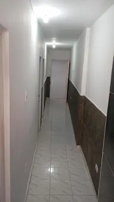 a long hallway with white walls and a white tile floor at Apartamento #7 in Puerto Colombia