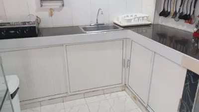 a kitchen with white cabinets and a sink at Apartamento #7 in Puerto Colombia