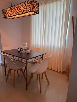 a dining room with a black table and white chairs at the best view of Barranquilla in Barranquilla