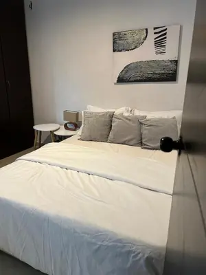a bedroom with a bed with white sheets and gray pillows at the best view of Barranquilla in Barranquilla