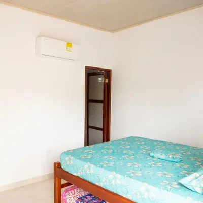 a bedroom with a bed with a blue comforter at Cabañas Capilla Del Mar in San Bernardo del Viento