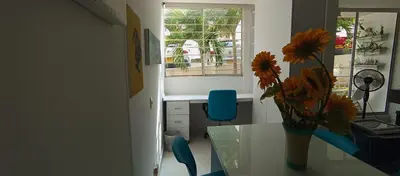a room with a table and a vase with flowers on it at Apto para 6, cerca a la ciudad amurallada in Cartagena de Indias